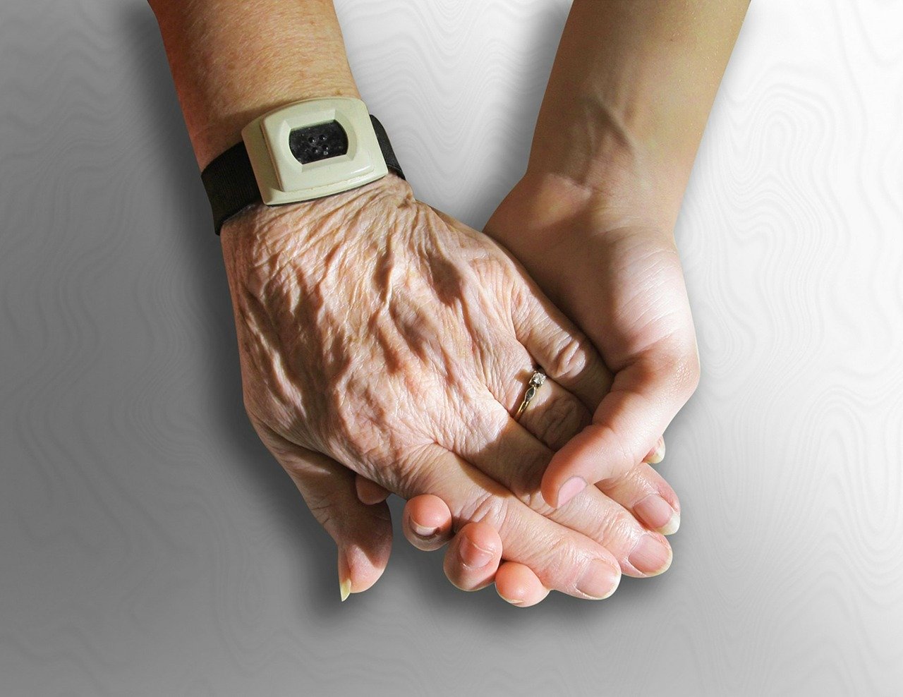 Woman holding an older woman's hands